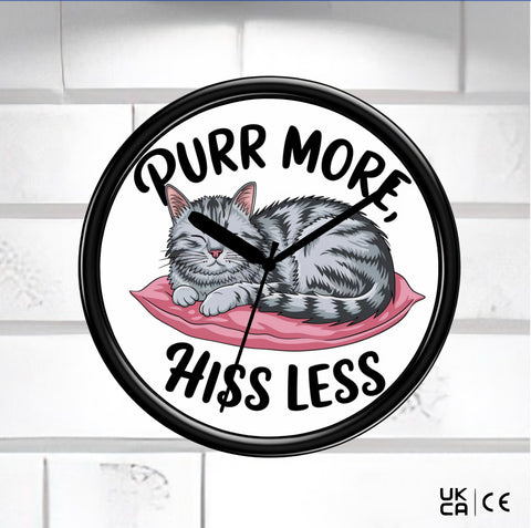 Black Wall Clock on a white tile background face of clock is a cat with the saying Purr more hiss less