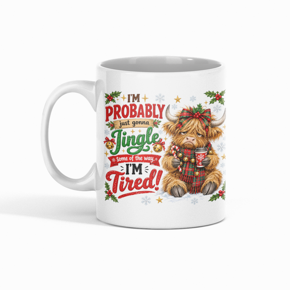 A white ceramic mug featuring a festive Christmas graphic of a Scottish highland cow holding a mug and surrounded by holiday text that reads 'I'm Probably Jingle Dandy Because I'm Tired!'.