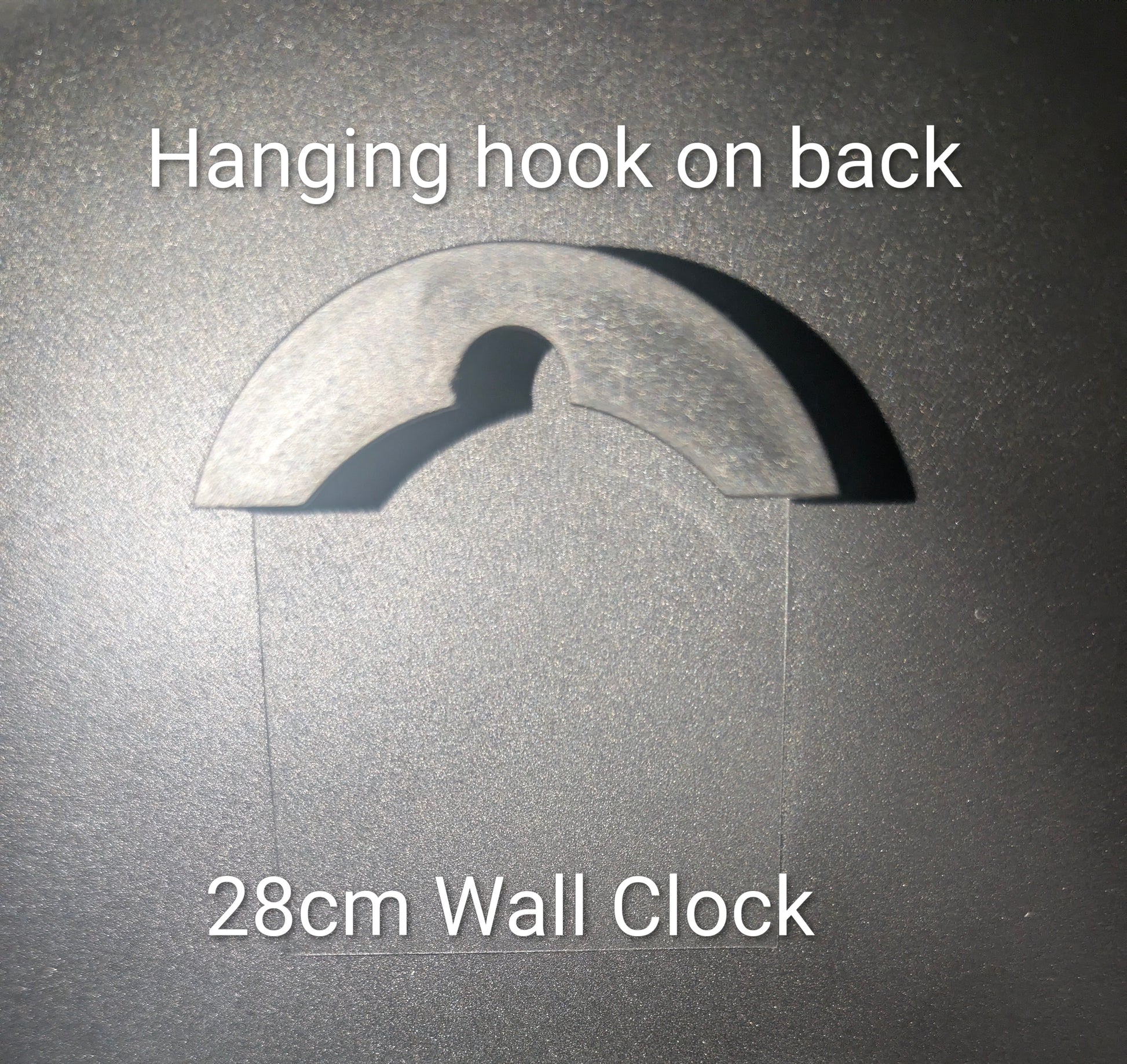 A wall clock shown against a dark textured background with overlaid text reading 'Hanging hook on back' and '28cm Wall Clock', indicating the back of the clock has a hanging hook and the clock diameter is 28 cm.