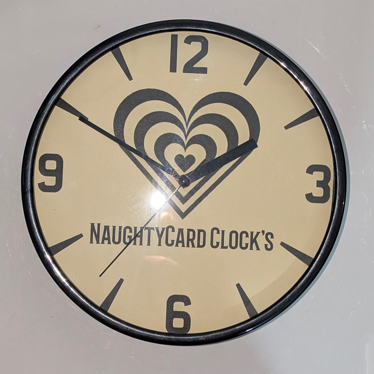 Front view of black wall clock on plain white background