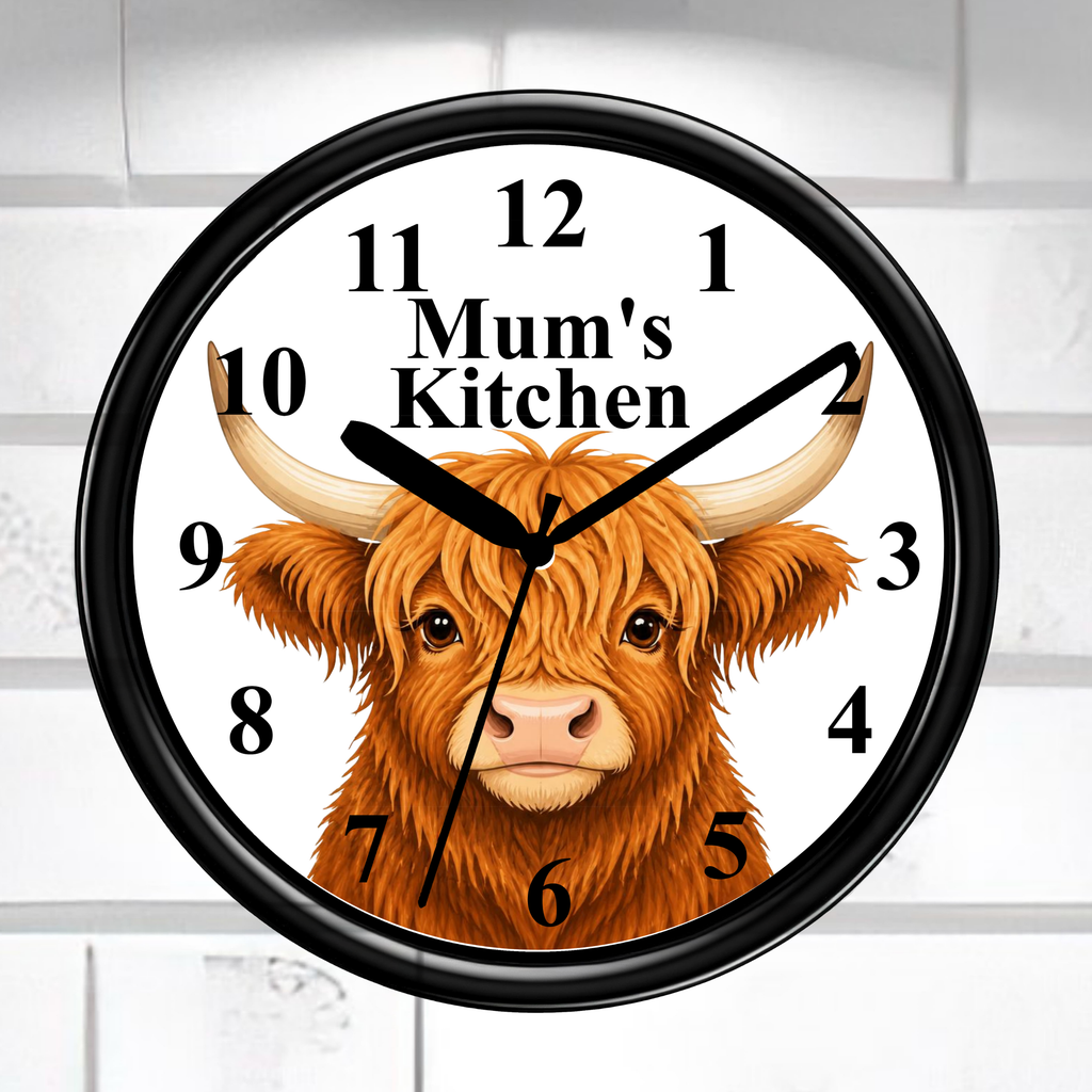 A round wall clock with a black frame and a white face, featuring a brown highland cow illustration and the text 'Mum's Kitchen' at the center. The clock is mounted against a white tiled wall.
