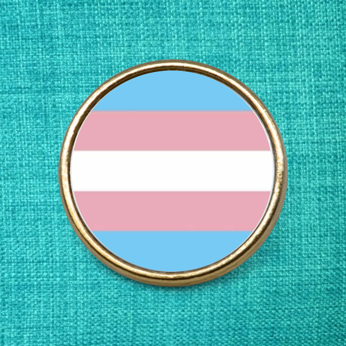 Gold Lapel Badge on a green background featuring the transgender pride flag design