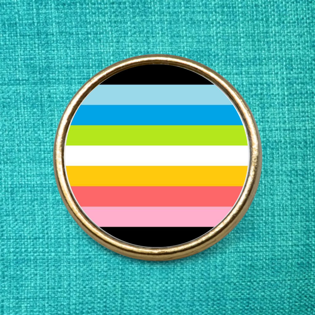 Gold Lapel Badge on a green fabric background featuring the Queer Pride Flag