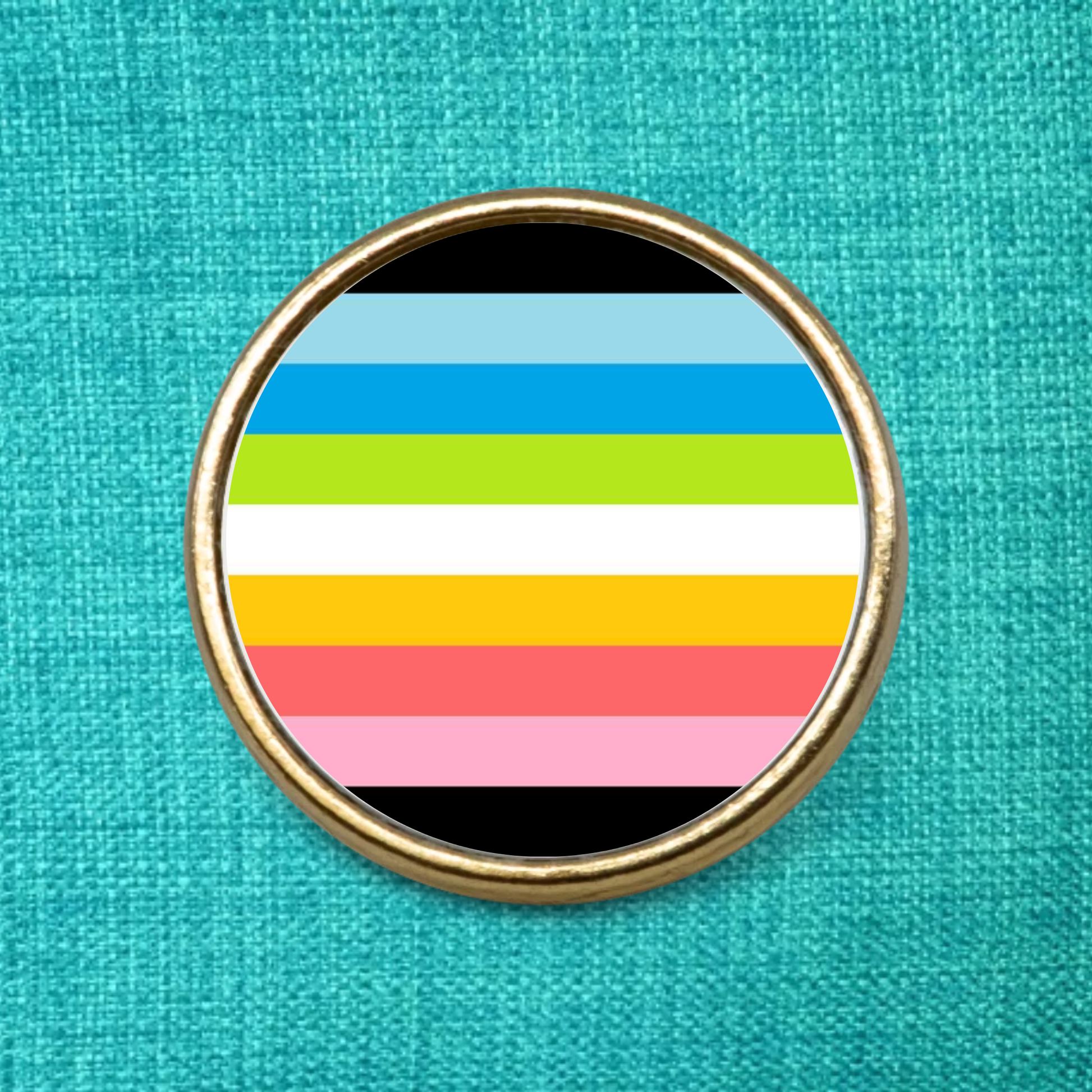 Gold Lapel Badge on a green fabric background featuring the Queer Pride Flag