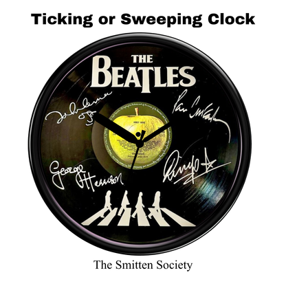 Clock with The Beatles' signatures and Abbey Road album cover design on a white background