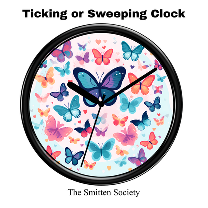 Wall clock with colorful butterfly design on a white background, brand 'The Smitten Society' visible.