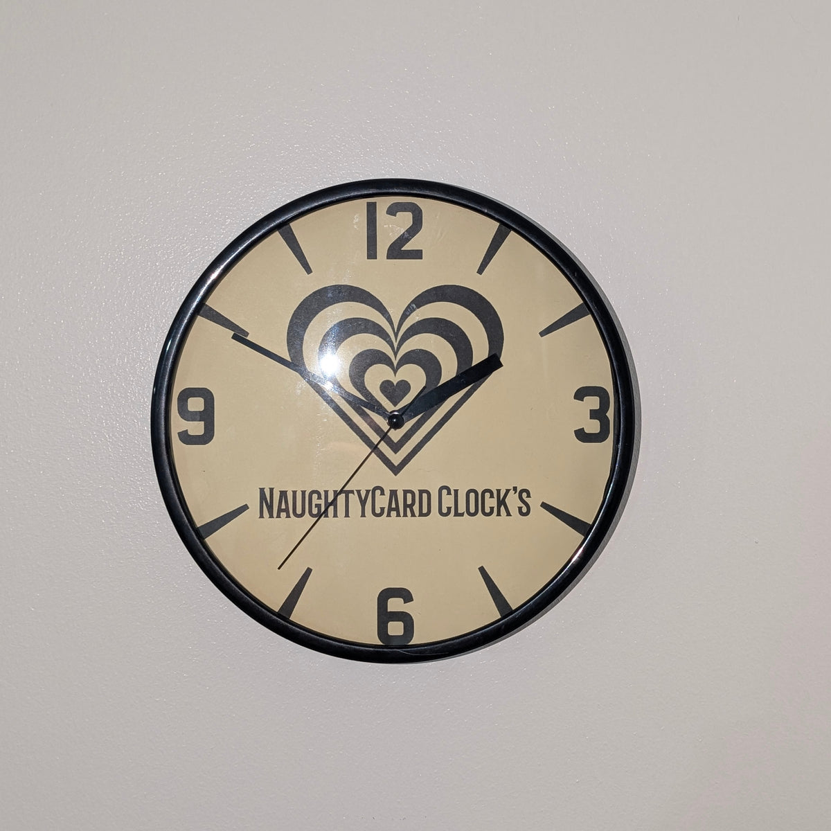 Full front view of value black wall clock on a plain white background