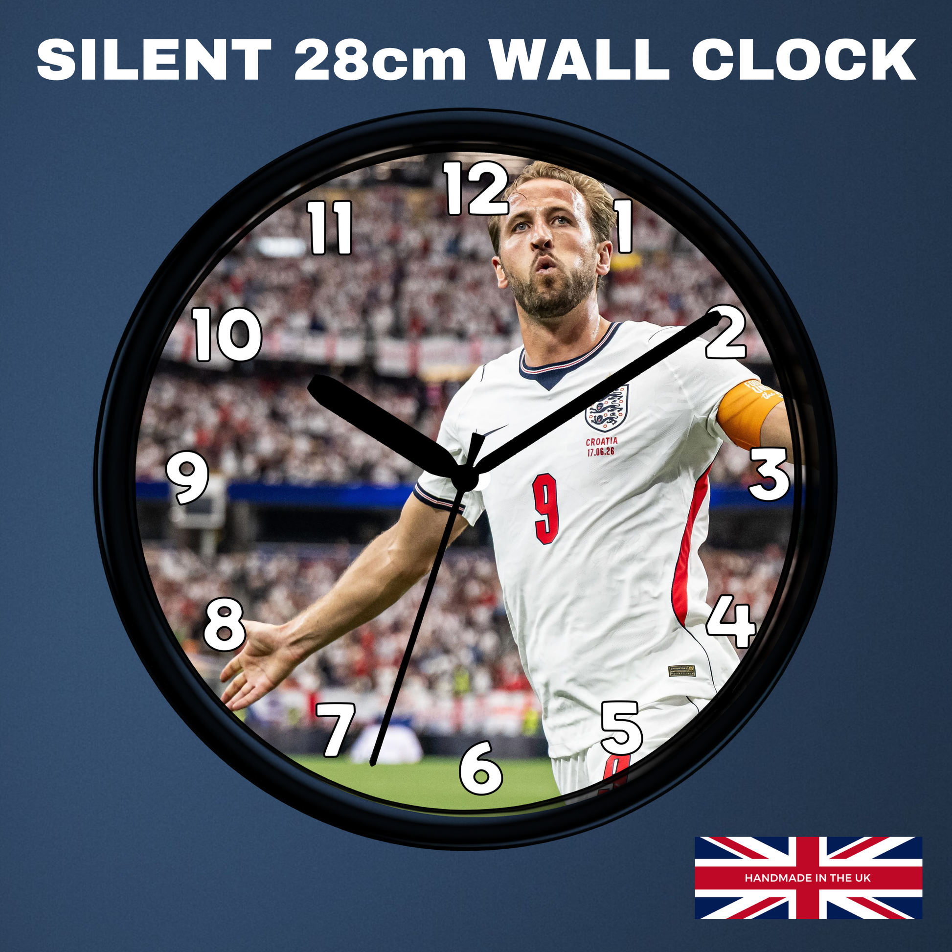 A round wall clock with a black frame and a printed design of football player Harry Kane in a white England jersey. The clock is shown against a dark blue background with the text 'SILENT 28cm WALL CLOCK' at the top and a small 'Made in UK' flag graphic at the bottom right.