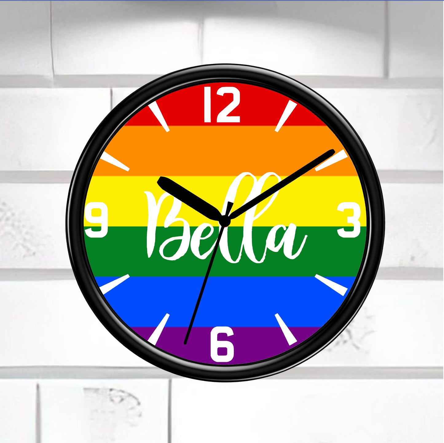 Gay Wall clock with rainbow design and 'Bella' text on a white brick wall background