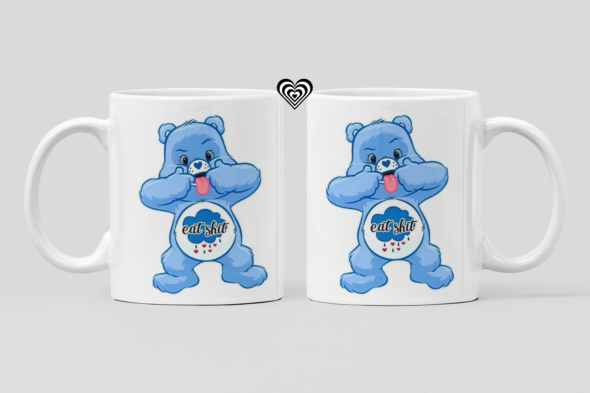 Two white mugs with blue cartoon naughty bears and 'eat sh*t' text on a light gray background