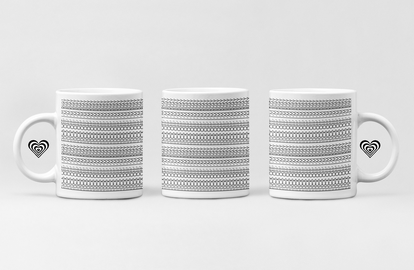 Three white mugs with black patterned designs on a light gray background