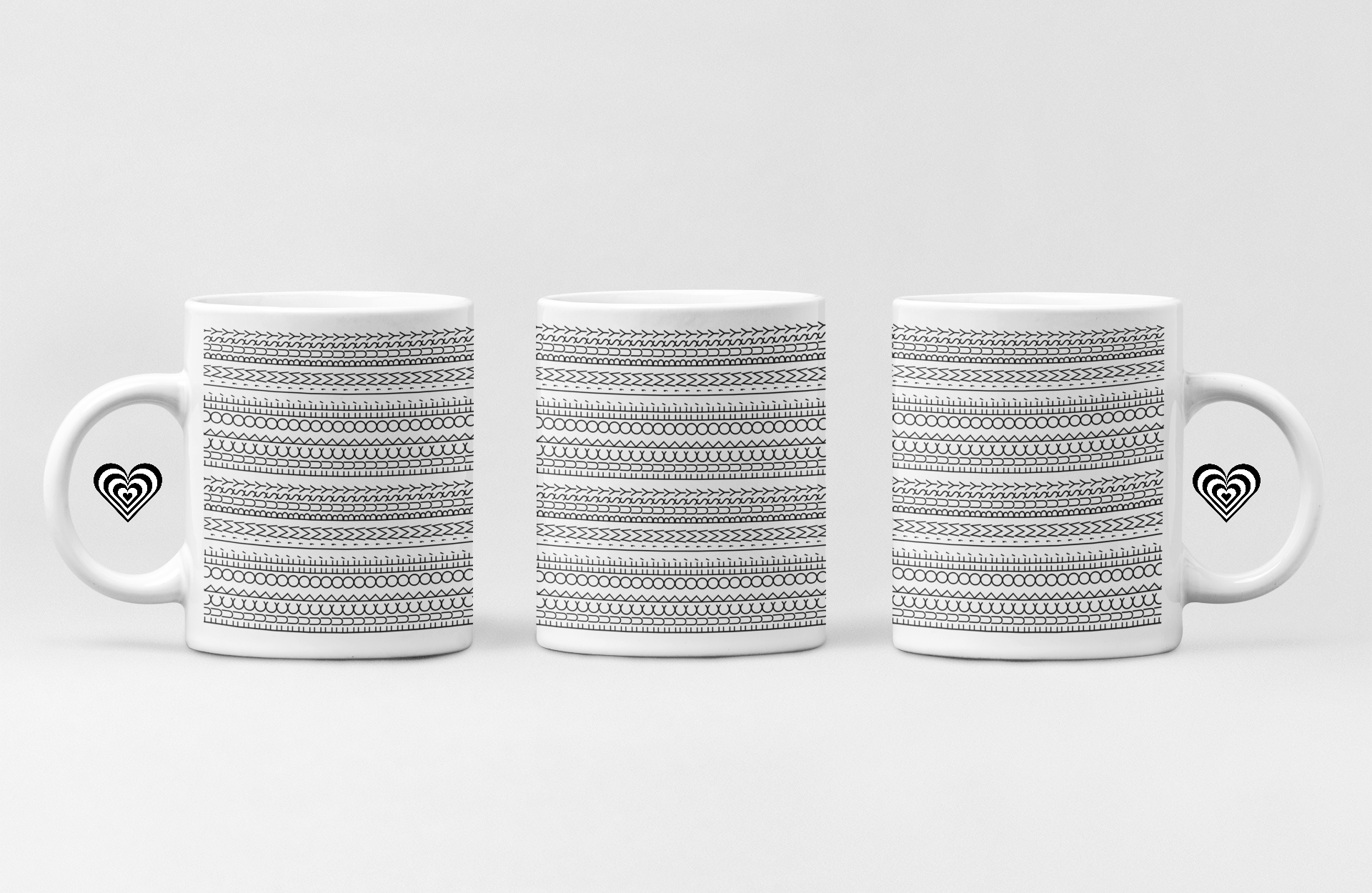 Three white mugs with black patterned designs on a light gray background