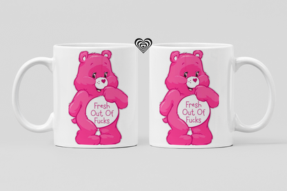 Two white mugs with pink cartoon naughty bears and 'fresh out of fu*ks' text on a light gray background