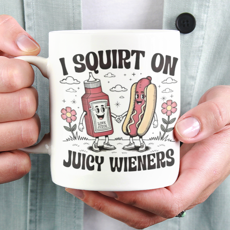 Person holding a mug with a humorous design of a hot dog and ketchup, text 'I squirt on juicy wireners'.