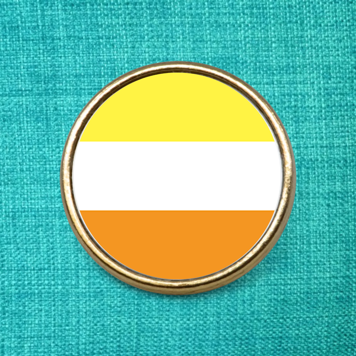 Maverique Pride Flag on a gold metal pin badge on a teal fabric background