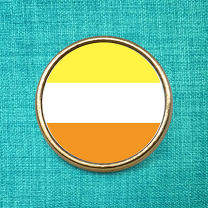 Maverique Pride Flag on a gold metal pin badge on a teal fabric background