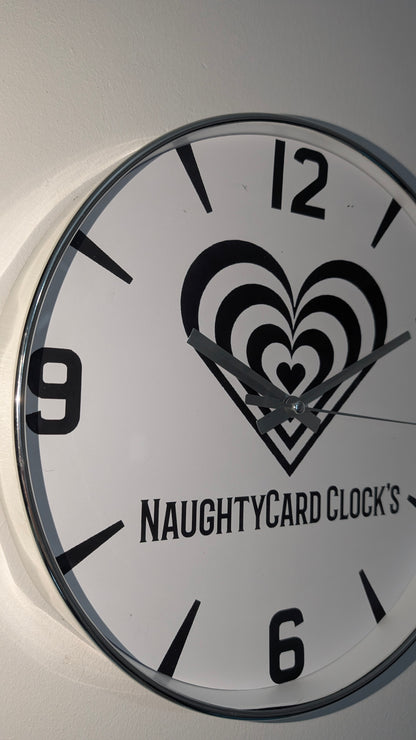 Wall clock with heart design and 'NaughtyCard Clocks' branding on a white background
