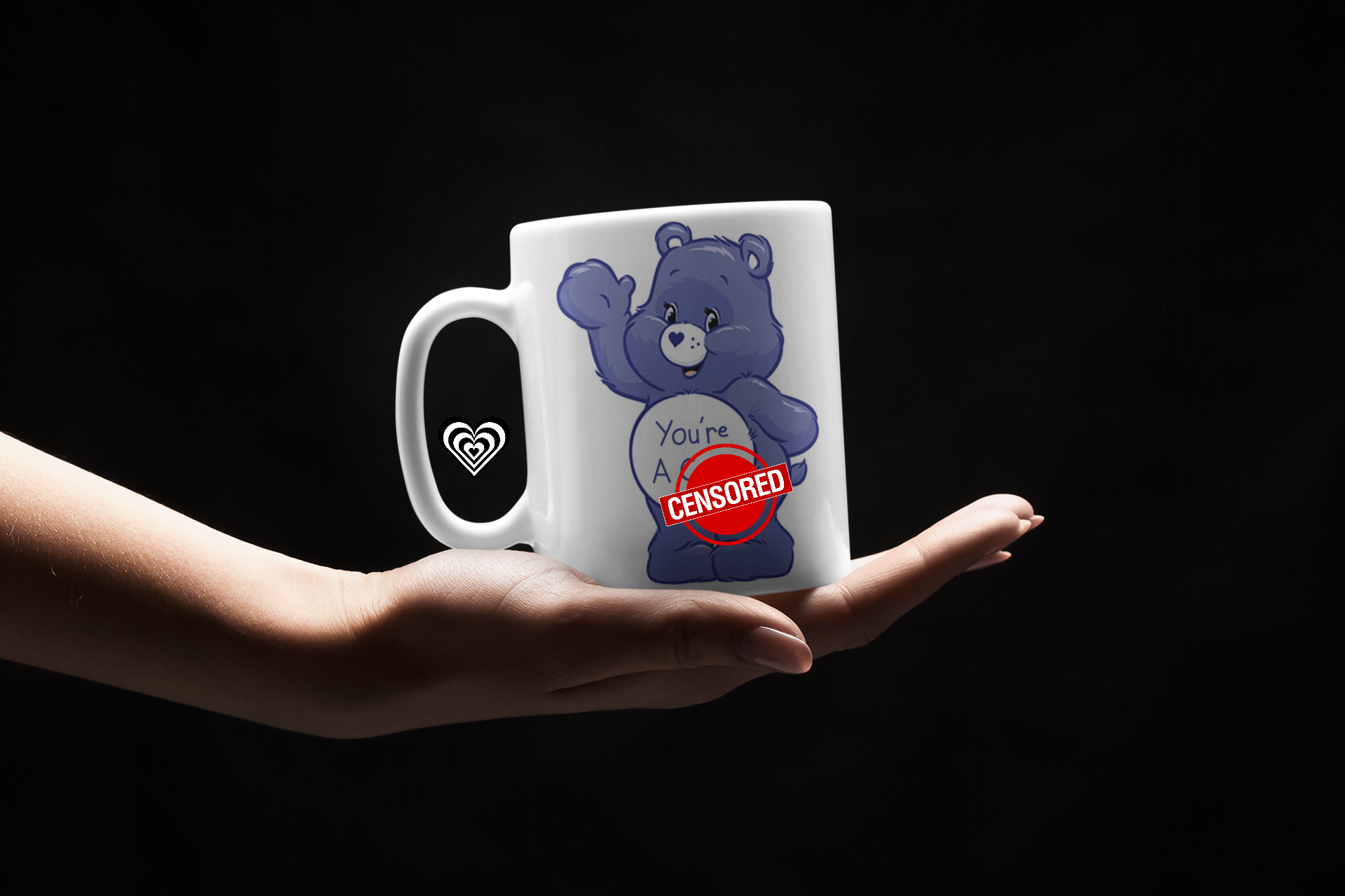 Mug with a blue bear graphic and text held by a hand against a black background