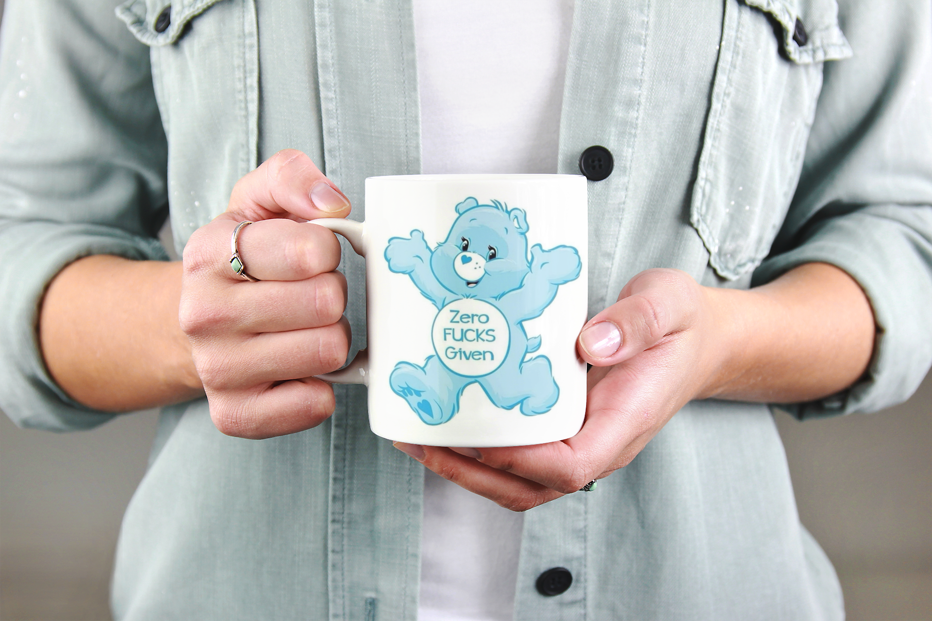 Person holding a mug with a cartoon character design on a neutral background
