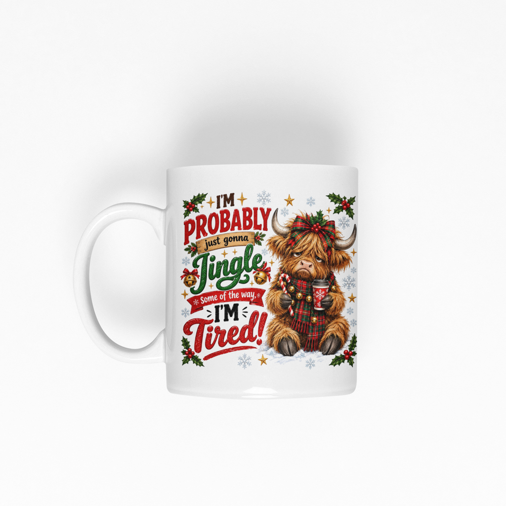 A white ceramic mug featuring a festive Christmas design with a highland cow holding a mug and the text 'I'm Probably Jingle Dandy Because I'm Tired!'.